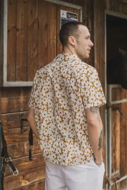 Chemise à manches courtes avec col et imprimé floral blanc sur fond camel